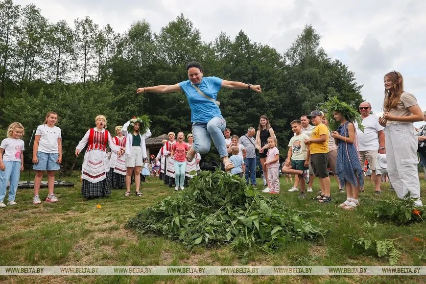 Гости прыгают через импровизированный костер на Купалье в Беловежской пуще 6 июля 2023 года. Фото: БЕЛТА
