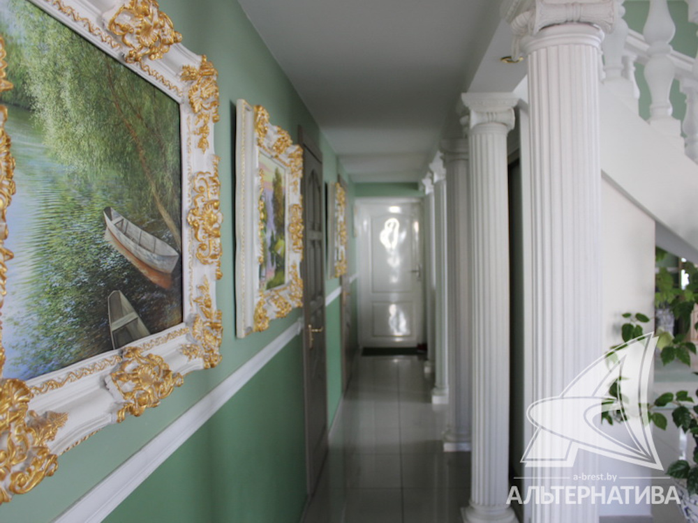 Картины в тяжелых полупозолоченных рамах и колонны в холле.