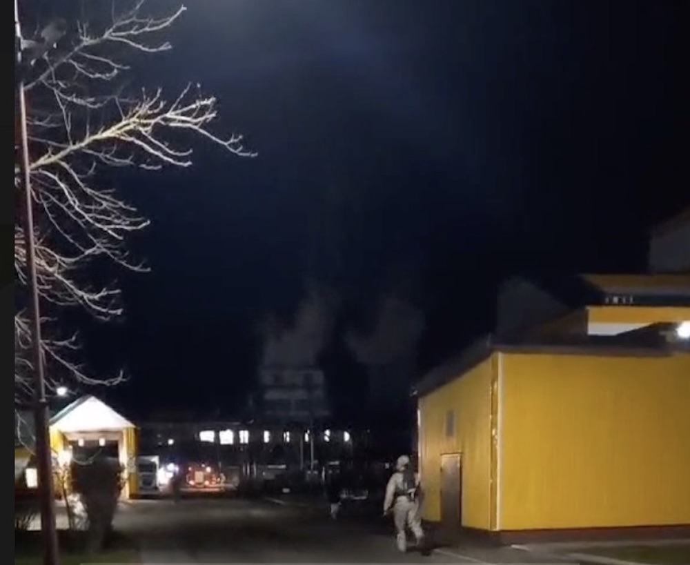 Работник одной из экстренных служб бежит на место происшествия на Брестском мясокомбинате. Вдали видны очертания столбов из пара. Скриншот видео Виртуальный Брест.