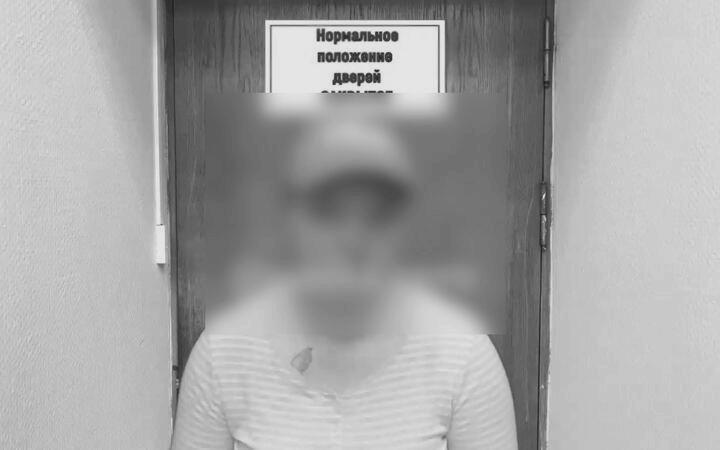 Задержанный человек стоит у двери с табличкой. Кадр «покаянное видео».