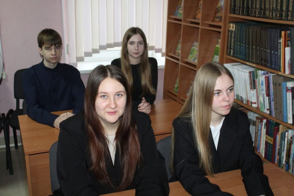 молодные люди сидят за партами